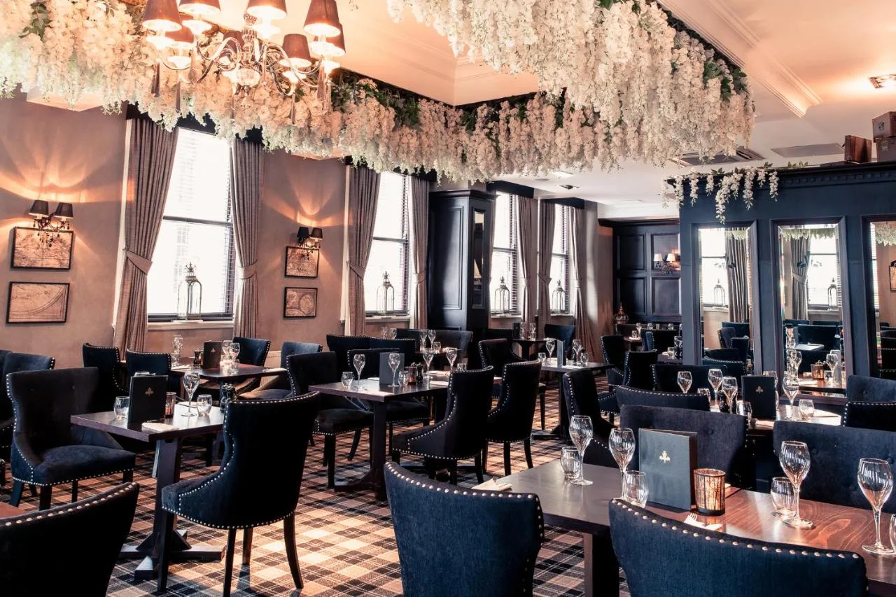a dining room with tables and chairs and chandeliers at The Vermont Hotel Newcastle in Newcastle upon Tyne