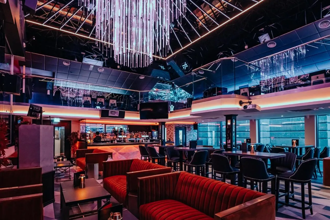 a restaurant with red couches and a bar at The Vermont Hotel Newcastle in Newcastle upon Tyne